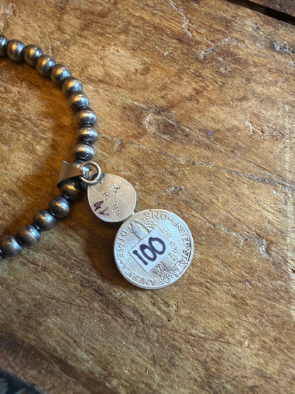 Devin 5 mm machine made beads 18 inches long with lobster closure and coin pendant with stone stamped by the artist(pendant)